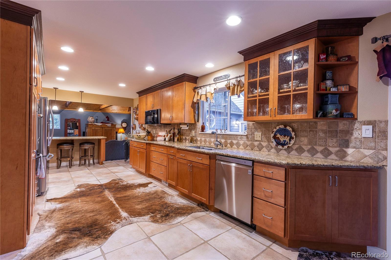 18975 Shadowood Drive Monument, CO 80132 - Photo 12 of 48 a kitchen with stainless steel appliances granite countertop a stove and a sink