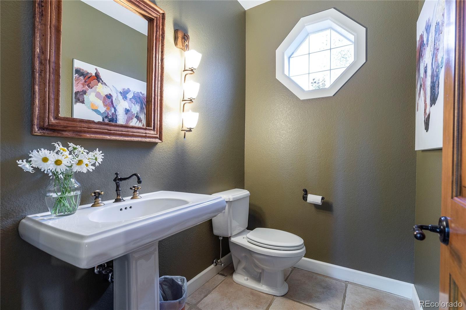 18975 Shadowood Drive Monument, CO 80132 - Photo 17 of 48 a bathroom with a toilet a sink and mirror