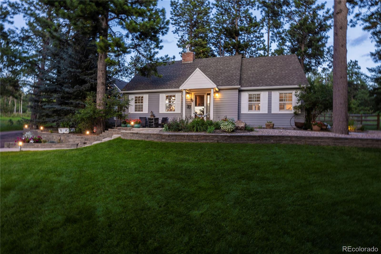 18975 Shadowood Drive Monument, CO 80132 - Photo 2 of 48 a front view of a house with a garden and trees