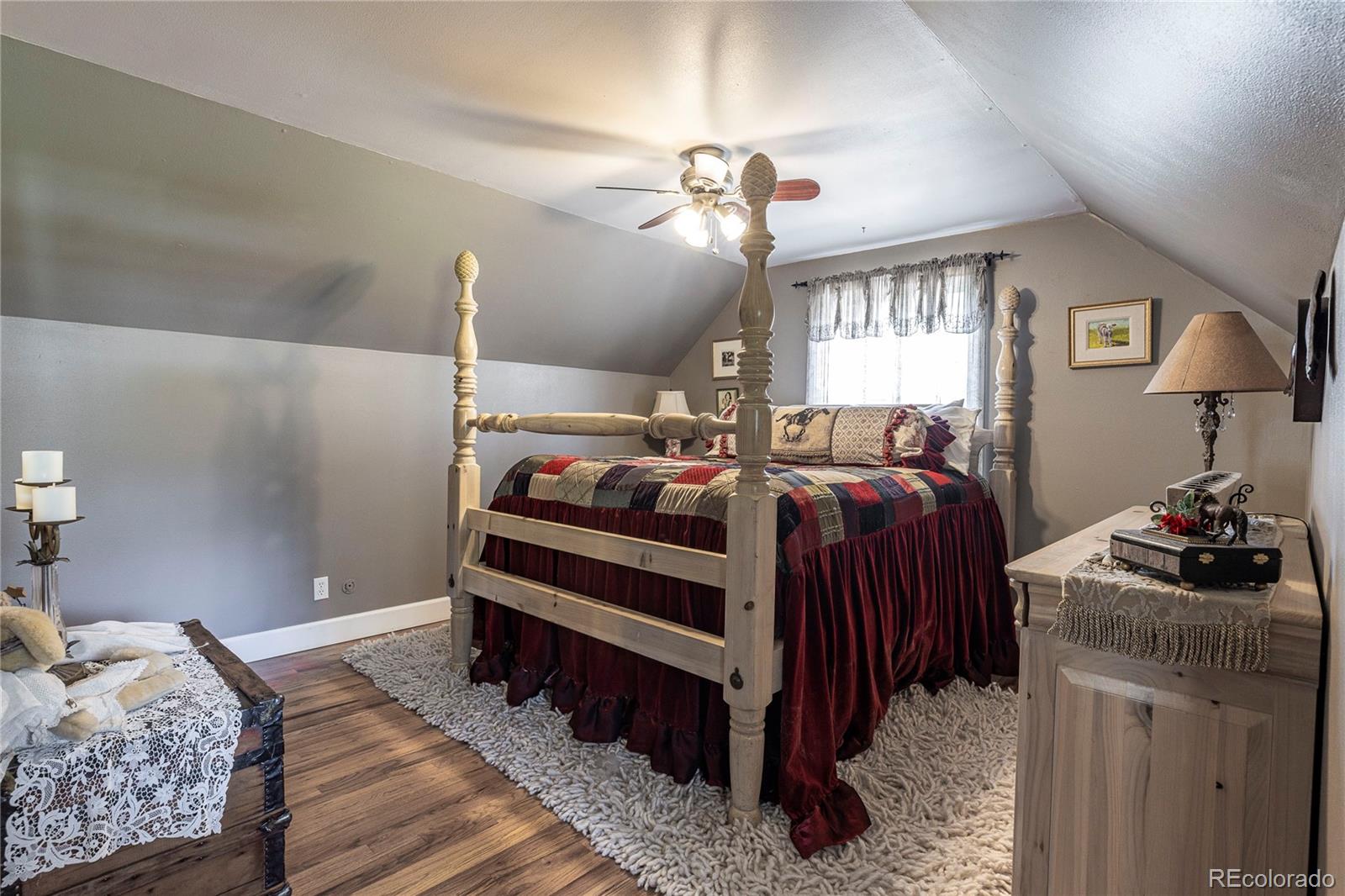 18975 Shadowood Drive Monument, CO 80132 - Photo 24 of 48 a bedroom with a bed and a chandelier