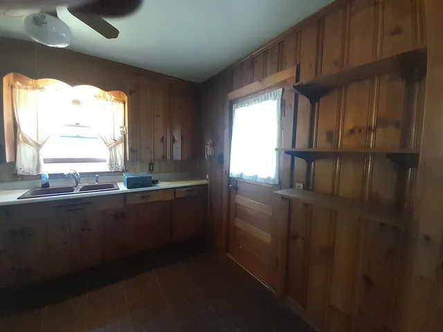 a kitchen with kitchen island a stove a sink and a window