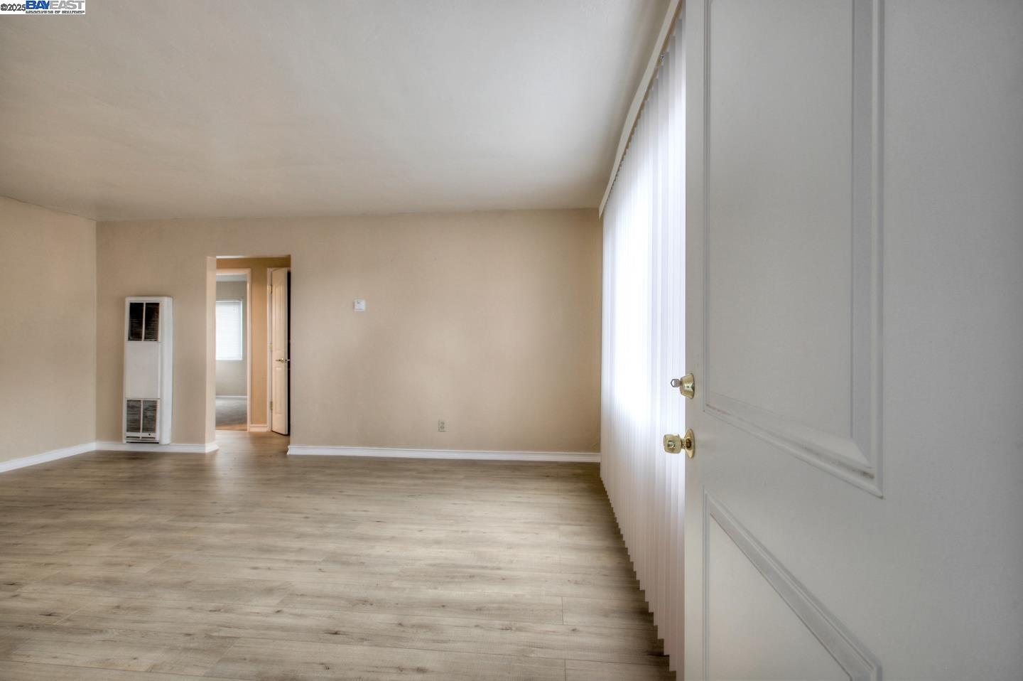 7448 Lockwood Street Oakland, CA 94621 - Photo 13 of 35 a view of an empty room with wooden floor and a window