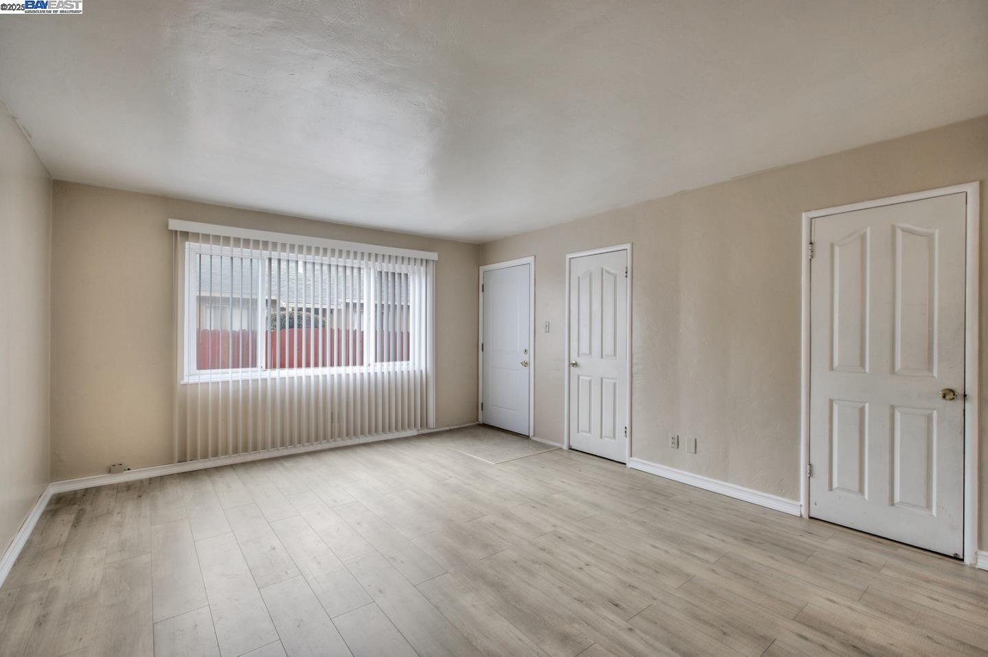 7448 Lockwood Street Oakland, CA 94621 - Photo 16 of 35 an empty room with wooden floor and windows