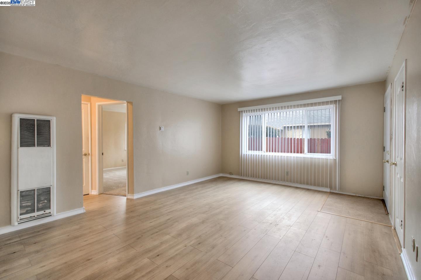 7448 Lockwood Street Oakland, CA 94621 - Photo 17 of 35 an empty room with wooden floor and windows