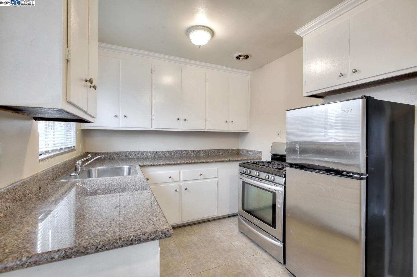 7448 Lockwood Street Oakland, CA 94621 - Photo 19 of 35 a kitchen with granite countertop cabinets stainless steel appliances and a sink