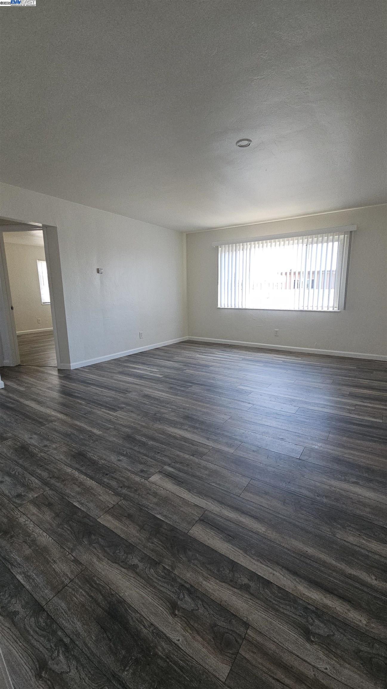 7448 Lockwood Street Oakland, CA 94621 - Photo 7 of 35 wooden floor in an empty room with a window