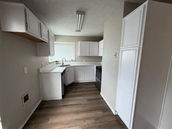 a kitchen with a sink a refrigerator and cabinets