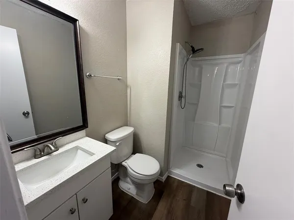 a bathroom with a granite countertop sink toilet and shower
