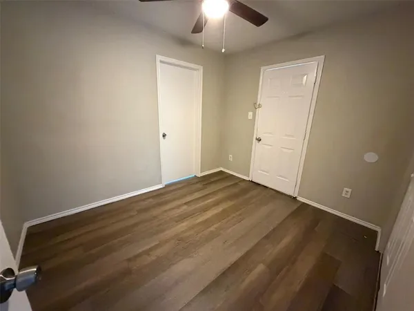 an empty room with wooden floor closet and chandelier fan