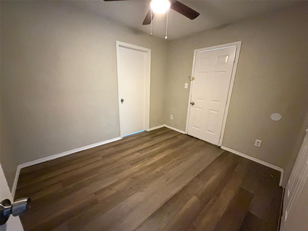 7401 Wagonwheel Road Fort Worth, TX 76133 - Photo 8 of 9 an empty room with wooden floor closet and chandelier fan