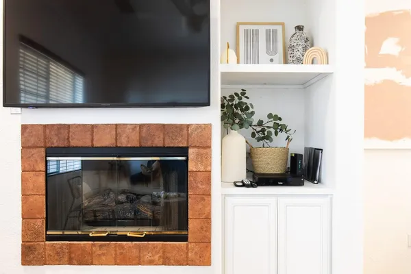a room with a fireplace and a potted plant