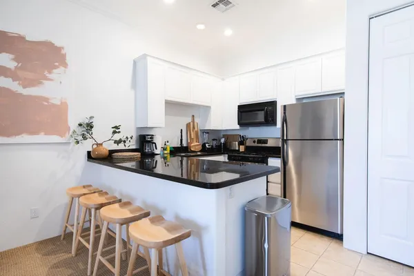 a kitchen with stainless steel appliances granite countertop a sink refrigerator and microwave
