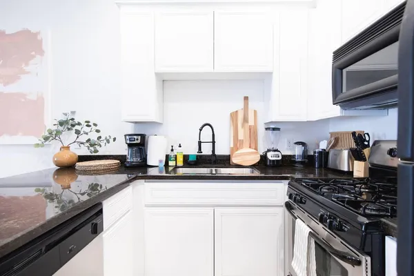 a kitchen with stainless steel appliances granite countertop a sink stove and cabinets