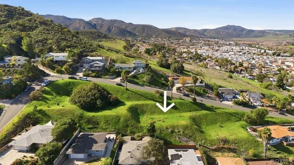 an aerial view of residential house with parking and mountains