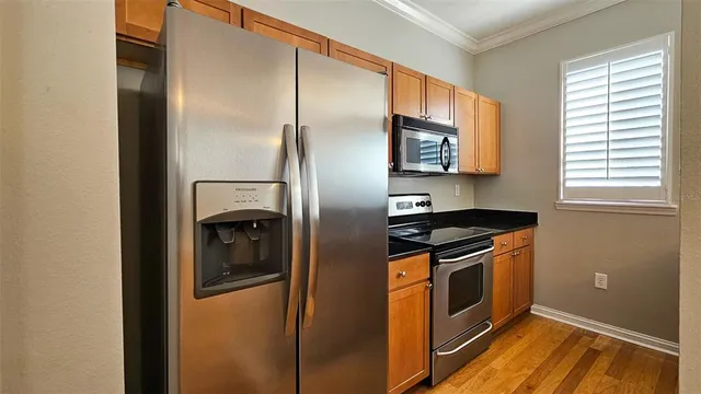 a kitchen with stainless steel appliances granite countertop a refrigerator and a sink