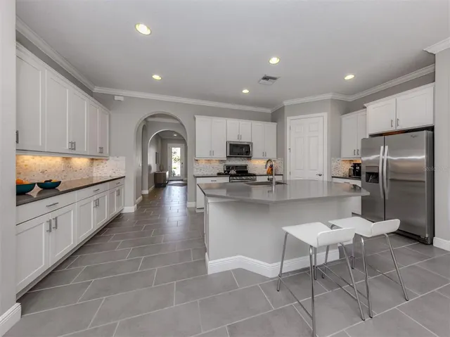 a large kitchen with kitchen island granite countertop a large counter top stainless steel appliances and cabinets