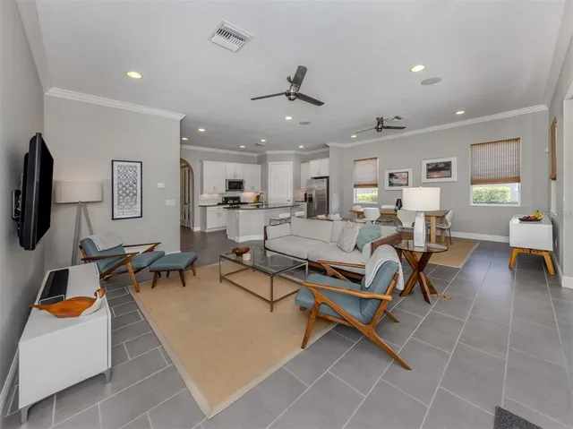 a living room with furniture a flat screen tv and kitchen view