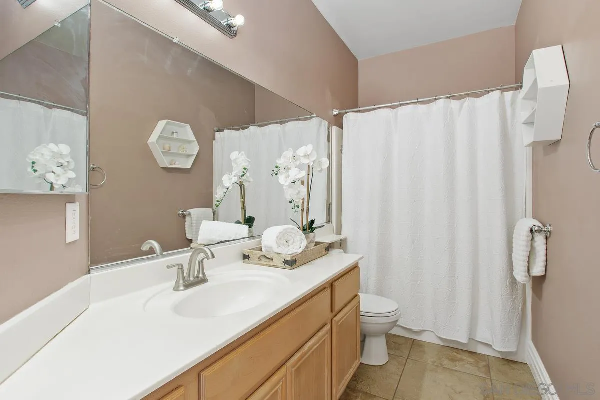 1132 Tabernacle Lane San Jacinto, CA 92582 - Photo 23 of 39 a bathroom with a sink a toilet and shower curtain
