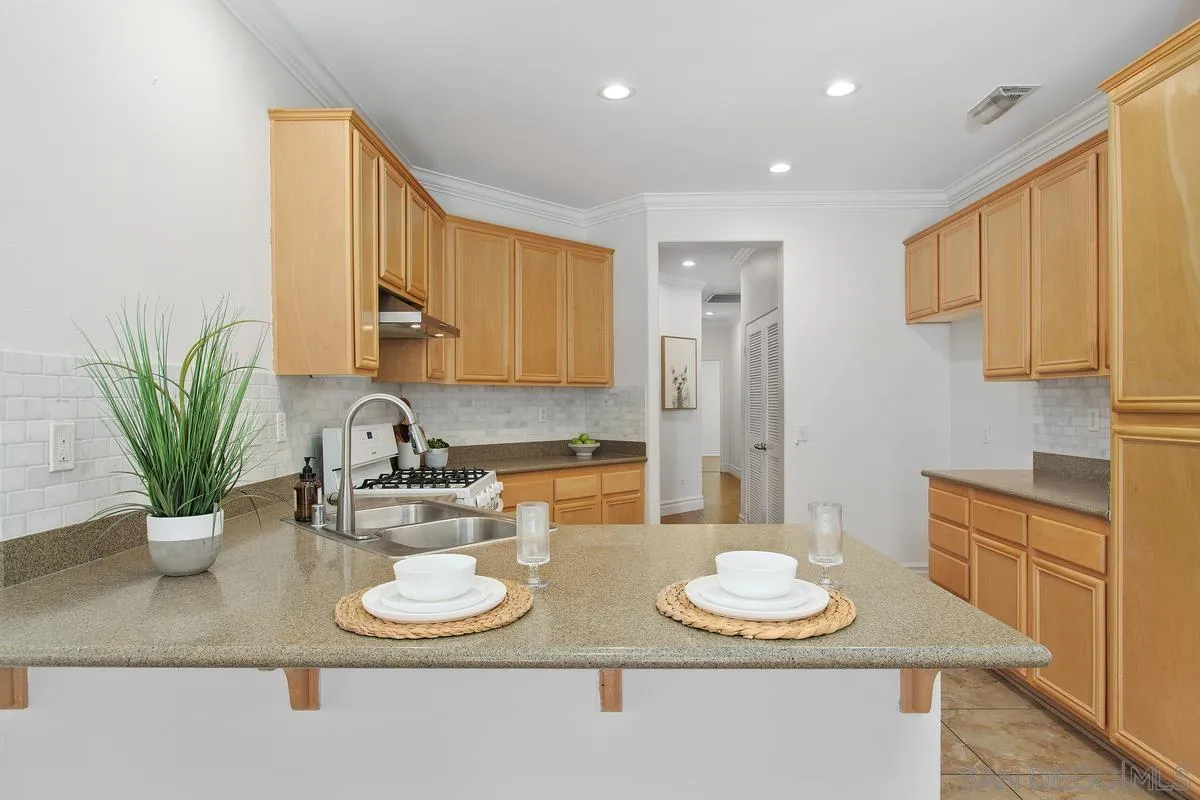 1132 Tabernacle Lane San Jacinto, CA 92582 - Photo 10 of 39 a kitchen with kitchen island a sink and wooden cabinets
