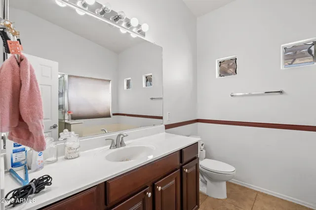 a bathroom with a sink vanity granite and toilet