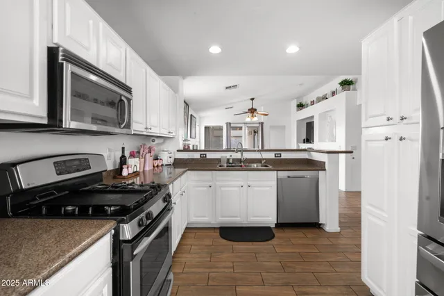 a kitchen with stainless steel appliances granite countertop a stove sink and cabinets