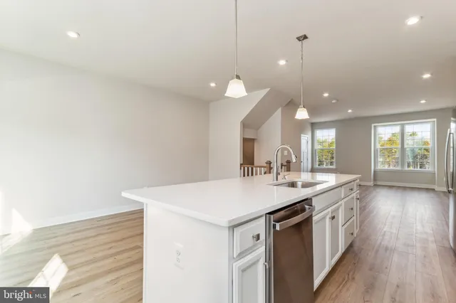 a kitchen with a sink and wooden floor