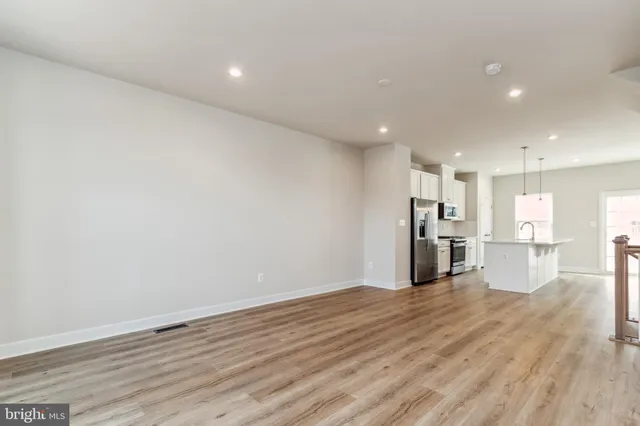 a view of kitchen with refrigerator and wooden floor