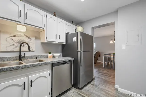 a kitchen with stainless steel appliances granite countertop a refrigerator and a sink