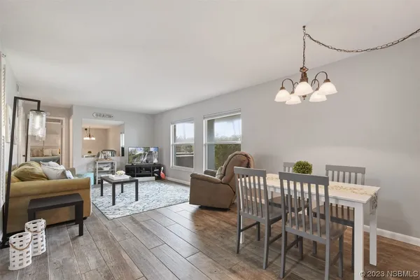 a living room with furniture a chandelier and a wooden floor