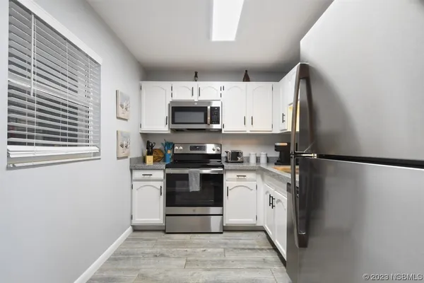 a kitchen with stainless steel appliances a refrigerator stove and microwave