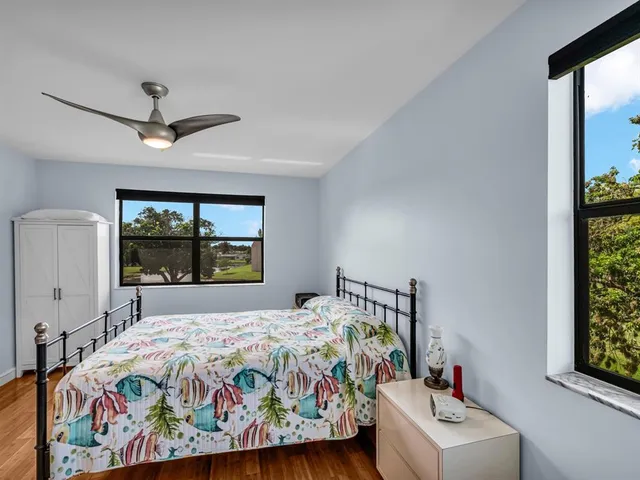 a bedroom with a bed a window and a chandelier