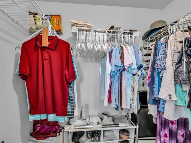 a view of walk in closet with clothes and shoes