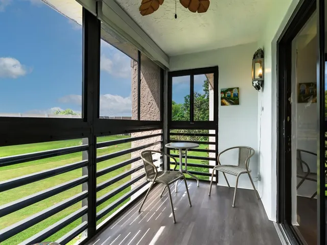a view of a porch with chairs and wooden floor