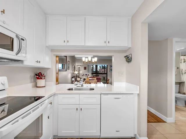 a kitchen with white cabinets and white appliances