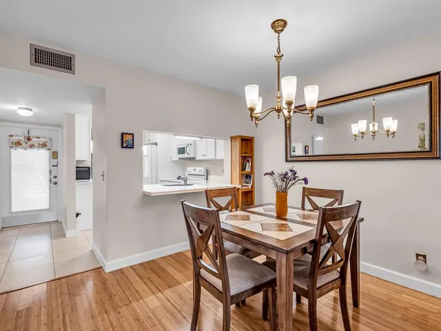 a view of a dining room with furniture a chandelier and wooden floor