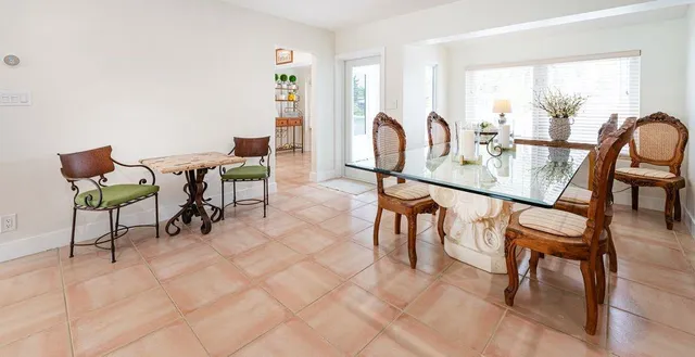 a dining room with furniture and a floor to ceiling window