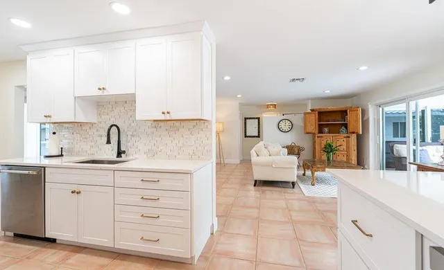 a spacious bedroom with a bed a couch and white cabinets