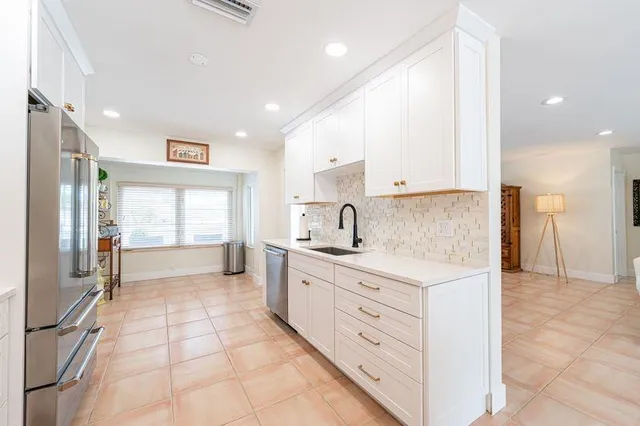 a large kitchen with a stove a sink dishwasher and a refrigerator