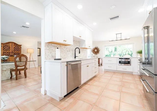a large white kitchen with cabinets