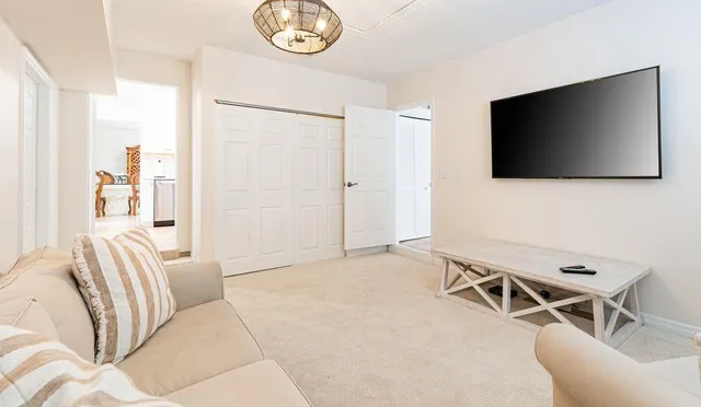 a living room with furniture a flat screen tv and a window