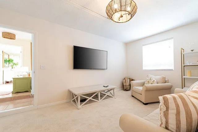 a living room with furniture a flat screen tv and a window