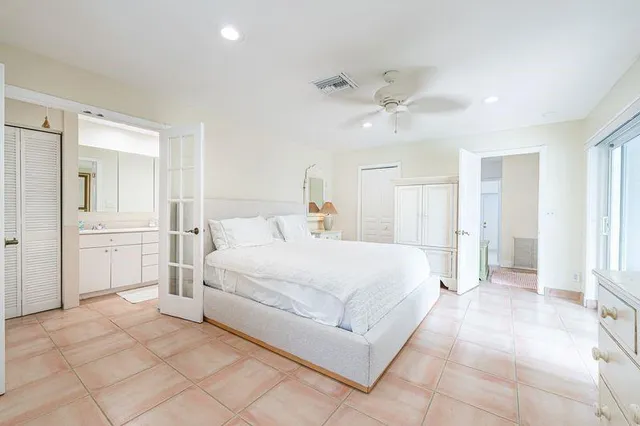 a spacious bedroom with a bed and a chandelier