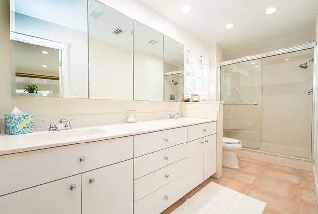 a bathroom with a granite countertop sink toilet a large mirror a shower and vanity