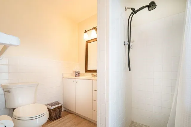 a bathroom with a granite countertop shower and a toilet