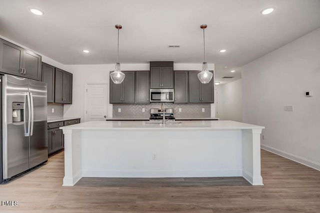 a large kitchen with kitchen island a sink stainless steel appliances and cabinets