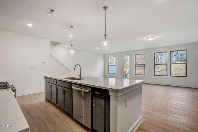a kitchen with sink stove and wooden floor