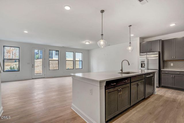 a kitchen with stainless steel appliances granite countertop a sink a stove and a wooden floors