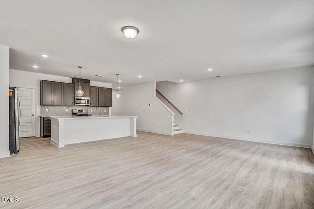 a view of kitchen with refrigerator microwave and wooden floor