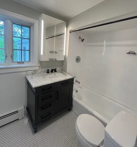a bathroom with a sink vanity mirror bathtub and toilet