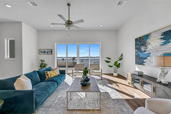 a living room with furniture a rug potted plant and a window